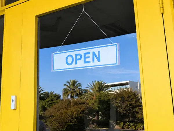 Yellow shopfront door with clean glass and an Open sign